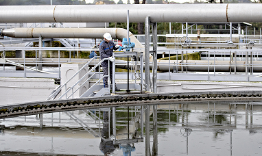 Operatore in tenuta antinfortunistica lavora ad una vasca di sedimentazione in un impianto industriale di Acea Ambiente